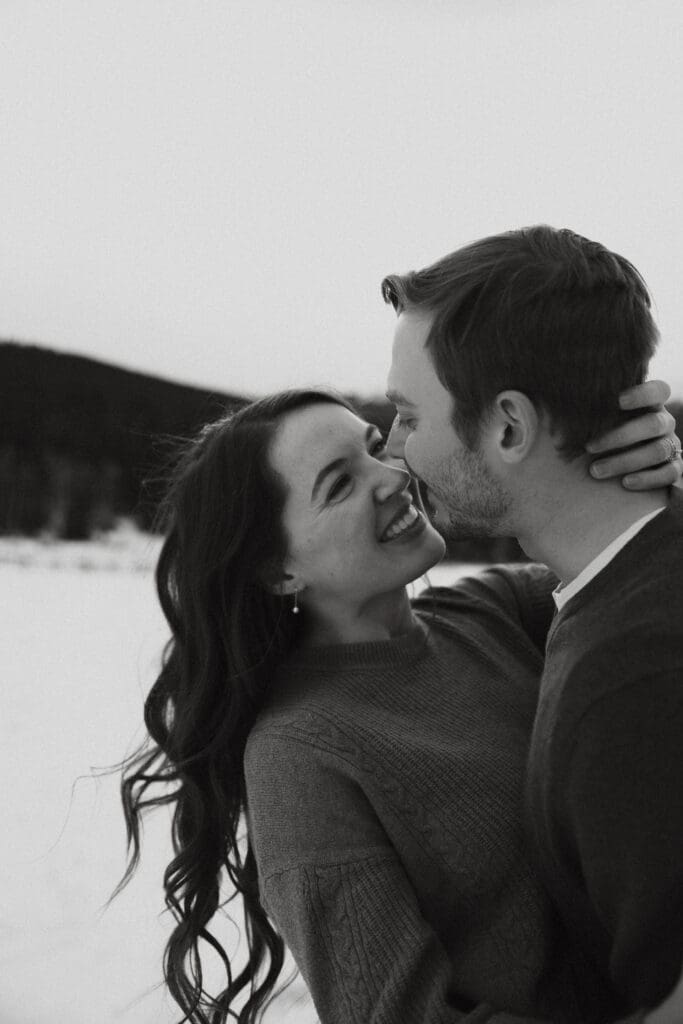 Photograph of engagement session in the Big Horn Mountains where the couple are embracing and smiling at each other.