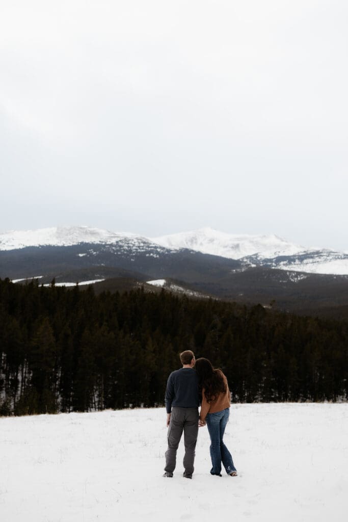 Photograph of engagement session in the Big Horn Mountains where the couple are looking out towards the mountain.