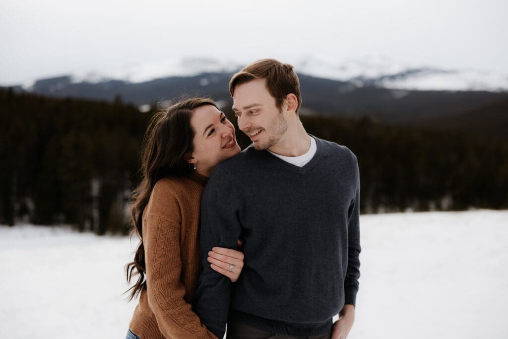 Photograph of engagement session in the Big Horn Mountains where the couple are looking at each other and smiling.