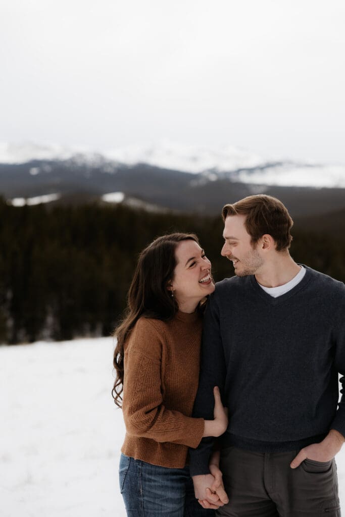Photograph of engagement session in the Big Horn Mountains where the couple are looking at each other and smiling.