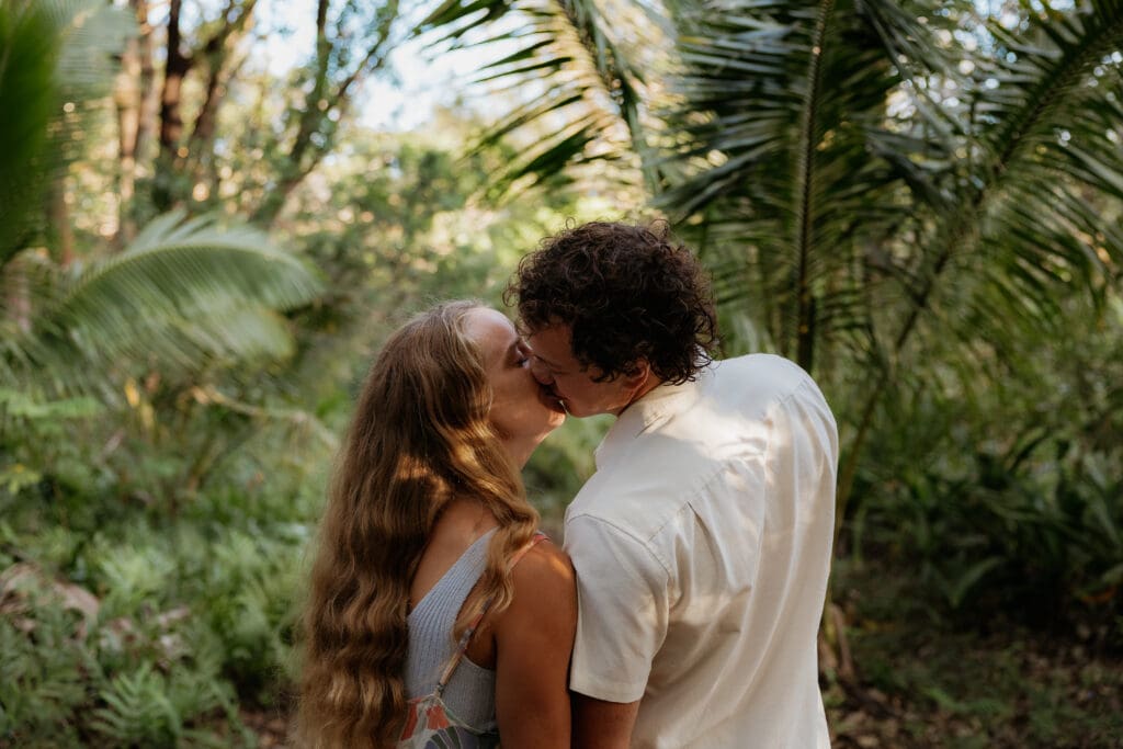 Engagement photo of man and woman kissing.
